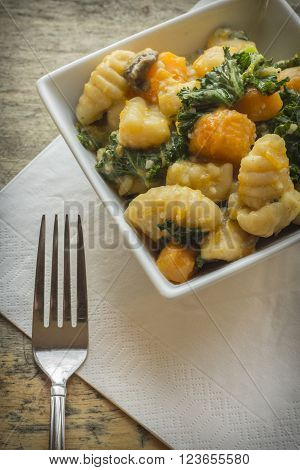 Vegetarian gnocchi dish with squash kale and mushrooms