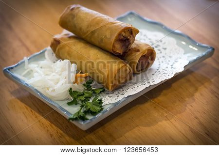 Japanese fried springrolls with shredded pickled radish and cilantro garnish