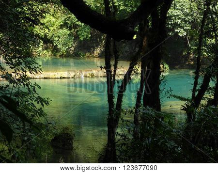 The beautiful azure and turquoise pools of Semuc Champey with a limestone dam as seen through the surrounding forests in Guatemala.
