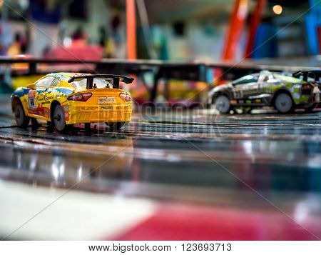 Two slot race cars on the tracks tracks.
