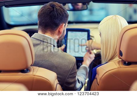 auto business, car sale, navigation and people concept - close up of couple sitting in cabriolet car with tablet pc computer at auto show or salon from back