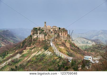 Civita di Bagnoregio, it is a small town in the Province of Viterbo in Italy. The town is famous for its position atop a plateau of friable volcanic tuff overlooking the Tiber river vally.
