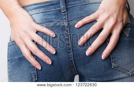 Woman with beautiful french manicure touching her bottoms