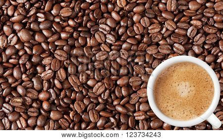Close-up of coffee beans background and white coffee cup