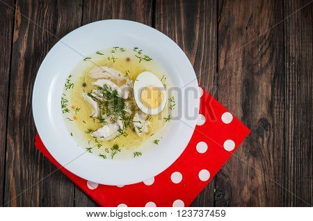 Chicken soup with noodles, carrots, eggs. closeup