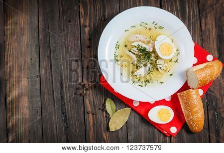 Chicken soup with noodles, carrots, eggs. closeup