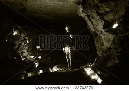 Spelunkers standing in chamber in abandoned mine in Wiltshire, UK. A cavernous space known as the Cathedral, in Box Freestone Mine which contains 90km of tunnels below Wiltshire
