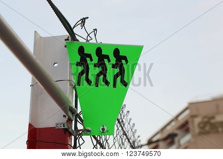 This is a sign to cross the road at the break of the wire fences.