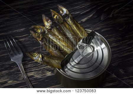 Close-up of Tinned capelin fish on dark wooden background