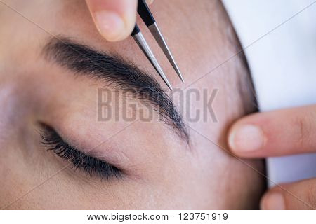 Woman getting her eyebrows shaped at spa
