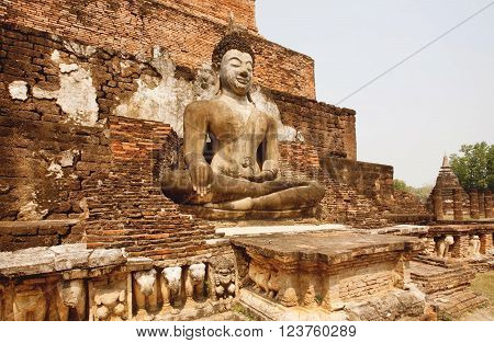 SUKHOTHAI, THAILAND - FEB 16: Buddhist landmark with carved temple walls and body of Buddha at Sukhothai historical park on February 16, 2015. Sukhothai historical park is a UNESCO World Heritage Site.