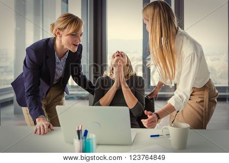 Three business women in modern office celebrating good project results. Post processed with vintage film filter.
