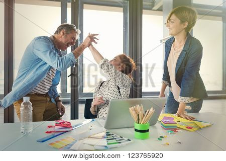 Business people in modern office celebrating good business results. Post processed with vintage filter.