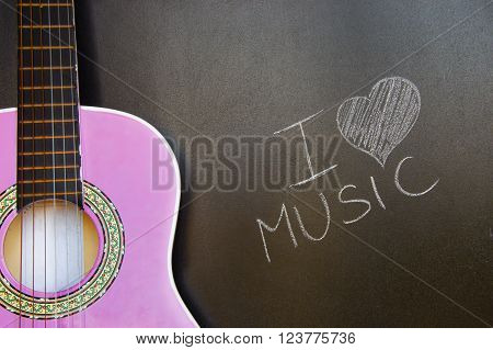 Music school for children with purple guitar closeup on blackboard background