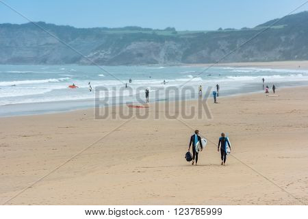 Surfers Walking Together Towards The Ocean