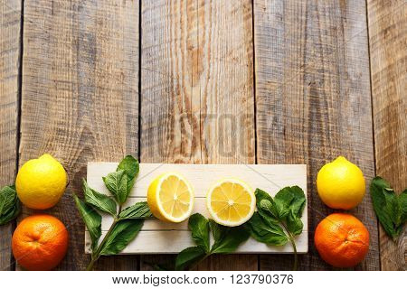 Freshly lemons and oranges with mint leaves on wooden boards