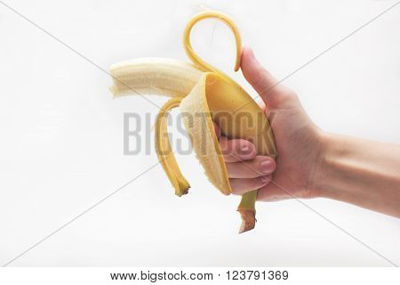 Banana fruit gun hold in caucasian white male hand over white background.