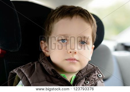 Sad Little Boy In Car Safety Seat.