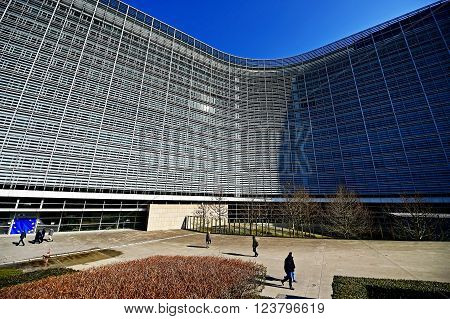 BRUSSELS BELGIUM - MARCH 16: People walk by the European Commission Headquarters also know as the Berlaymont building on March 16 2016 in Brussels.