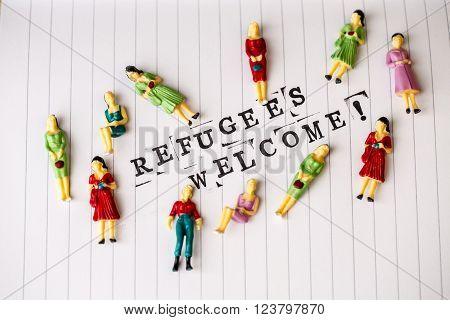 refugees welcome text on white line paper with woman figures around