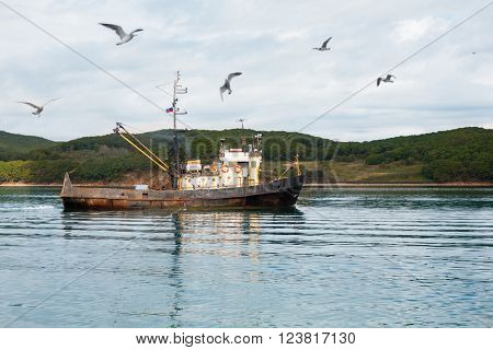 Small fishing seiner goes to fish in the sea. Russian coast of the Sea of Japan.