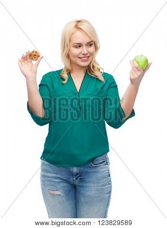 healthy eating, junk food, diet and choice people concept - smiling woman choosing between apple and cookie