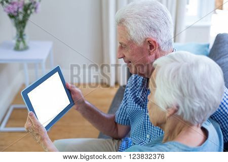 Senior couple using digital tablet at home