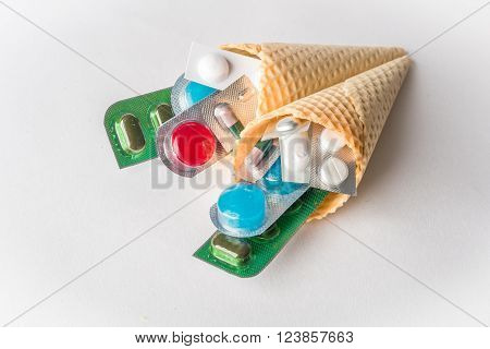 Mix of medicines and pills in wafer cones on white background