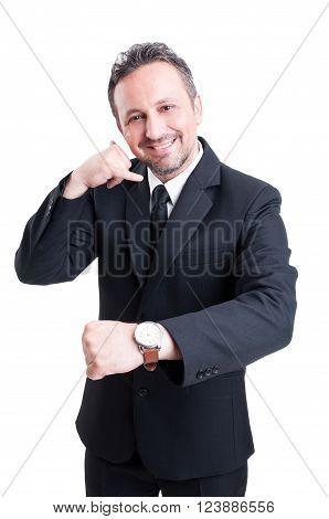 Business man showing watch and making call me gesture with hand