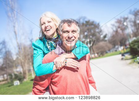 Senior couple portrait - Cheerful mature wife and husband walking outdoors and having fun