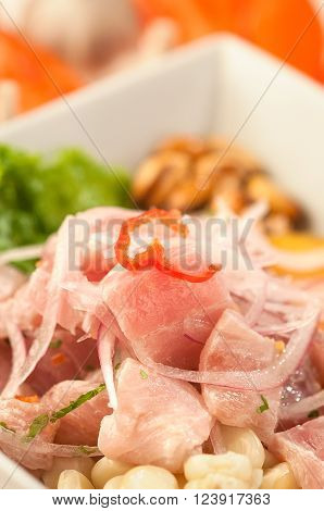 Fish ceviche, raw fish marinated in lime juice garnished with onion and hot peppers, a traditional dish from Peru.