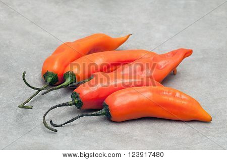 Group of aji amarillo hot chili peppers on stone background