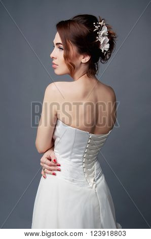 Elegant bride with brown short hair updo and bare shoulders white wedding dress