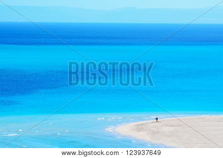 man fishing in a blue sea in Sardinia Italy