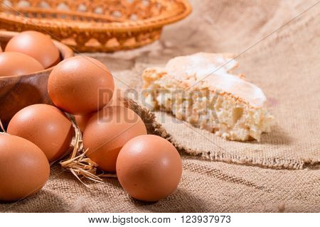 Eggs and pie on a sacking. One egg is broken rural style a close up