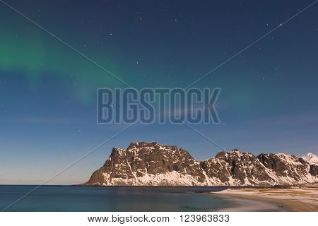 Northern lights over the sea at Utakleiv Beach Lofoten Islands Norway in the winter.