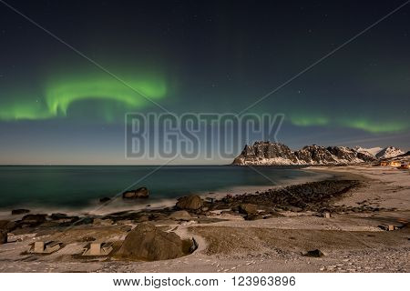 Northern lights over the sea at Utakleiv Beach Lofoten Islands Norway in the winter.