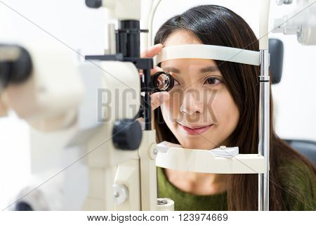 Woman cheking eye test in clinic