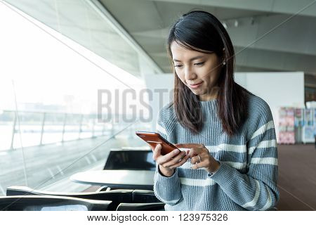 Woman use of mobile phone in inddor cafe