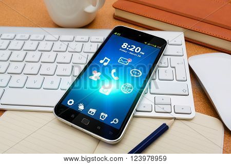 Modern mobile phone on table in office