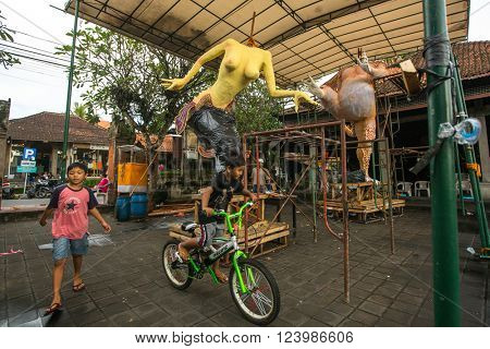 UBUD, INDONESIA - MAR 5, 2016: Unidentified local children during built Ogoh-ogoh are statues for the Ngrupuk parade, which takes place on eve of Nyepi day. Nyepi is a public holiday in Indonesia.