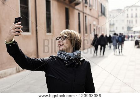 Traveling around the world. Beautiful modern woman making selfie. Local sights in the background.
