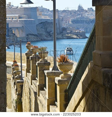 Street along the wall of fortress leading to the sea on the island of Malta in historical part of Valletta.