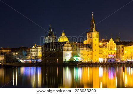 Beautifull night view of the Charles Bridge, the Old Town Bridge Tower, and the Old Water Tower, the Smetana Embankment and the Prague Beer Museum in Czech Republic New Year's Eve.