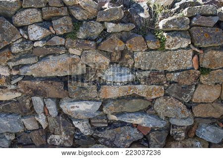 Closeup texture of an old stone rocky wall weathered by time