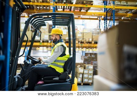 Man forklift driver working in a warehouse.