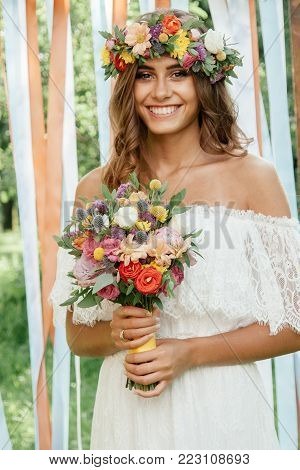 Beautiful Bride Holding Wedding Flower Bouquet In Hands Outdoors