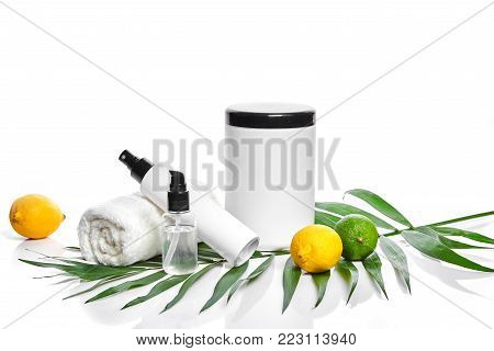 White bottles and two whole lemon and lime isolated on white background. The concept for advertising cosmetics. Still life. Copy space