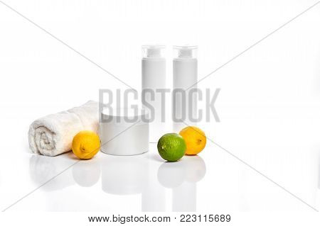 White bottles and two whole lemon and lime isolated on white background. The concept for advertising cosmetics. Still life. Copy space