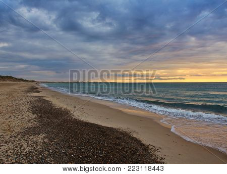 Evening scene in Jylland, Denmark. Summer clouds over the sea. Coastline. Summer sunset at Lild Strand, Jylland. Painting like impression.